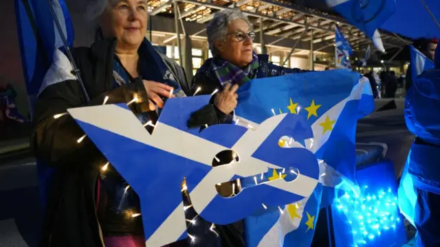 People attend a rally outside the Scottish Parliament in Edinburgh