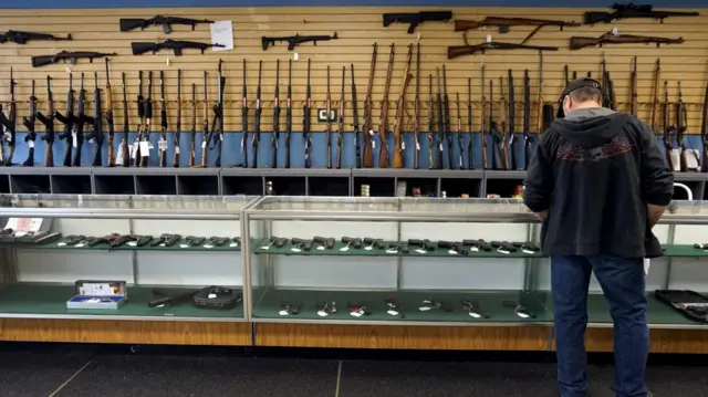 A customer looks over weapons for sale at the Pony Express Firearms shop in Parker, Colorado