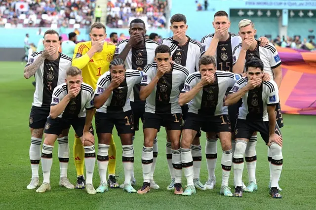 German players cover their mouths in protest against FIFA before their match against Japan at World Cup 2022