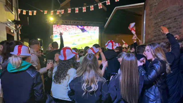 Women in hats waving flags