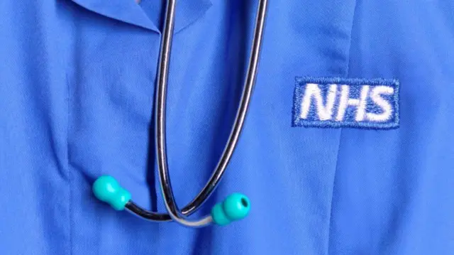 a close up of a NHS nurse's uniform and stethoscope