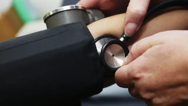 A nurse checking blood pressure