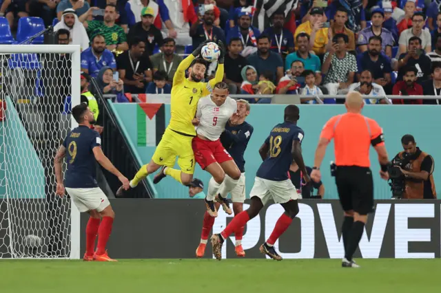 The Referee Szymon Marciniak of Poland looks on as Hugo Lloris of France snatches the ball from the head of Martin Braithwaite of Denmark during the FIFA World Cup Qatar 2022 Group D match between France and Denmark at Stadium 974