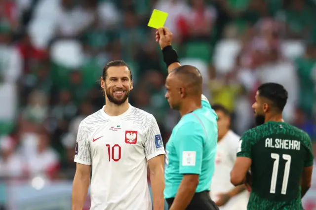 Referee Wilton Sampaio shows a yellow card to Grzegorz Krychowiak of Poland during the FIFA World Cup Qatar 2022 Group C match between Poland and Saudi Arabia at Education City Stadium on November 26, 2022 in Al Rayyan, Qatar.