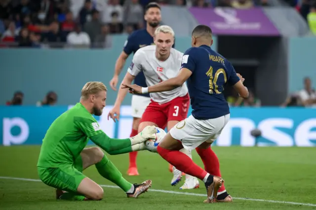 France's forward #10 Kylian Mbappe (R) challenges Denmark's goalkeeper #01 Kasper Schmeichel during the Qatar 2022 World Cup Group D football match between France and Denmark at Stadium 974 in Doha