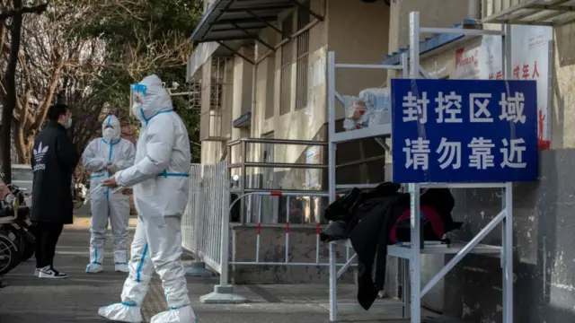 Epiedemic control workers wear protective suits to prevent the spread of COVID-19 as they control the entrance to an apartment complex on November 27, 2022 in Beijing, China.