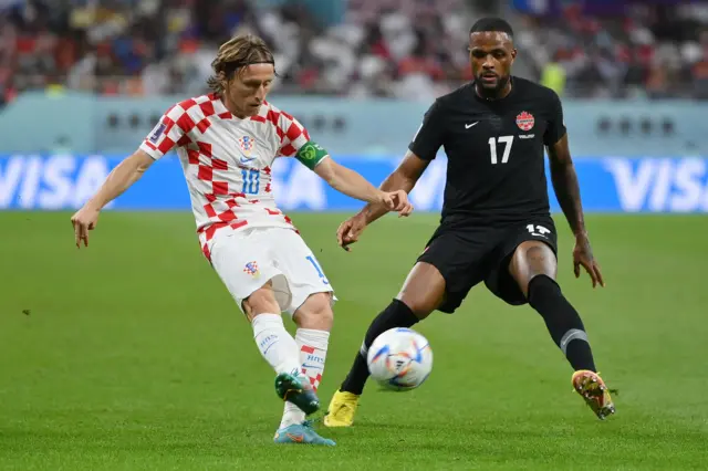 Luka Modric of Croatia controls the ball under pressure of Cyle Larin of Canada during the FIFA World Cup Qatar 2022 Group F match between Croatia and Canada at Khalifa International Stadium on November 27, 2022 in Doha