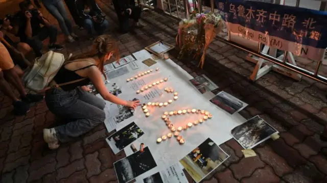 A woman lights a candle at a vigil in Hong Kong