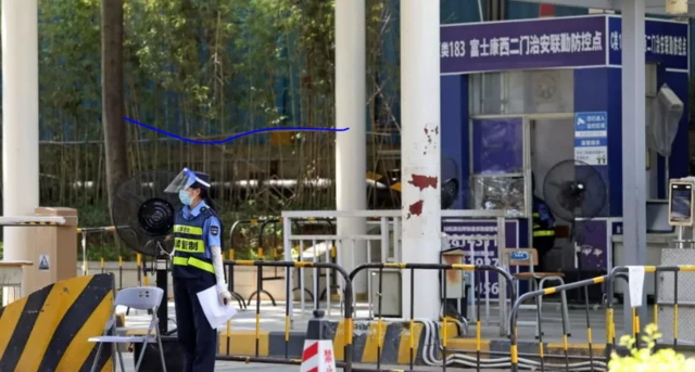 A security guard works at the entrance to another Foxconn factory in Shenzhen