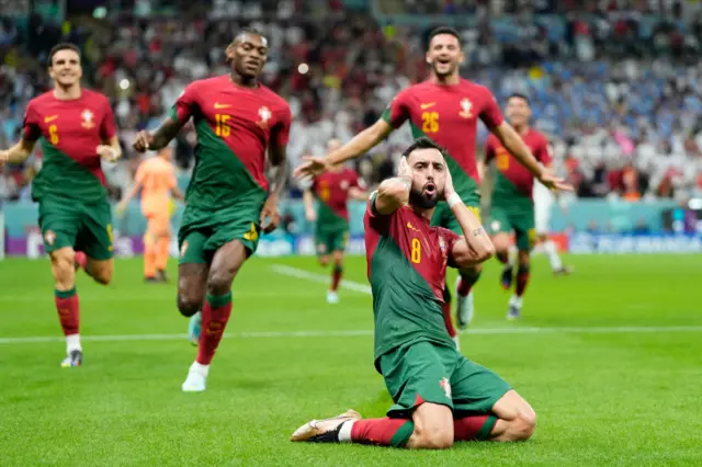 Portugal's midfielder #08 Bruno Fernandes (L) scores his team's second goal from the penalty spot during the Qatar 2022 World Cup Group H football match between Portugal and Uruguay at the Lusail Stadium in Lusail, north of Doha on November 28