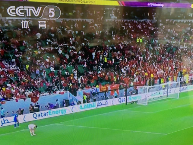 A photo of a CCTV screen showing fans in the stands at a World Cup game