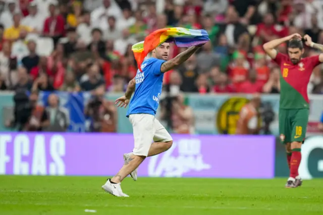 A protester on the pitch with rainbow flag during the FIFA World Cup Qatar 2022 Group H match between Portugal and Uruguay at Lusail Stadium on November 28, 2022 in Lusail City, Qatar.