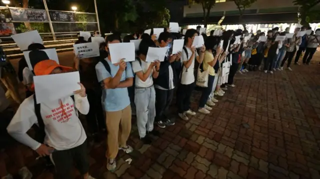 People seen holding up blank sheets of A4 paper at a protest in Hong Kong