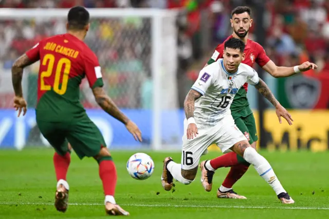 Mathias Oliveira of Uruguay battles for the ball with Joao Cancelo of Portugal and Bernardo Silva of Portugal during the Group H - FIFA World Cup Qatar 2022 match between Portugal and Uruguay at the Lusail Stadium on November 29, 2022 in Lusail City, Qatar