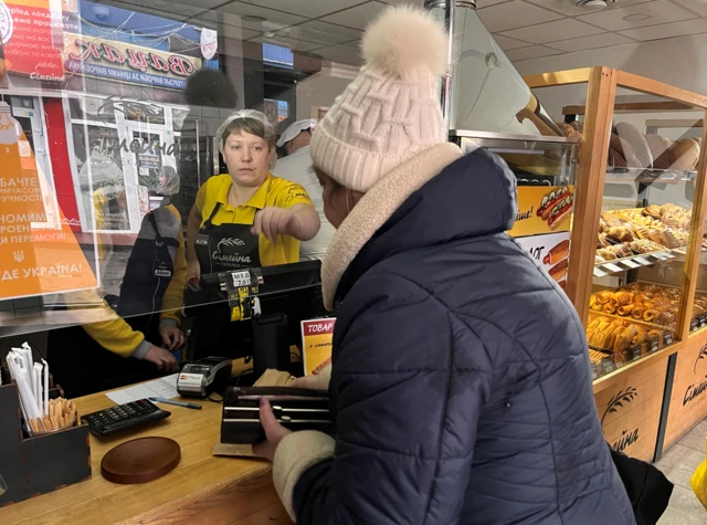 Woman being given change by a bakery worker in Kyiv