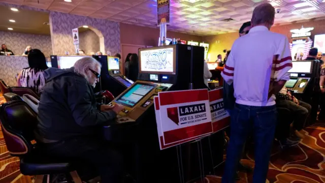 A man continues to gamble during a Laxalt rally in a casino in Las Vegas last month