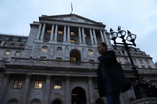 Man walking in front of the Bank of England