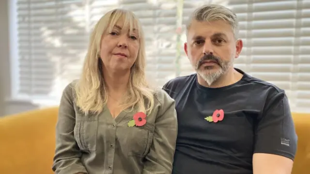 Lisa and Andrew Roussos sitting on a sofa