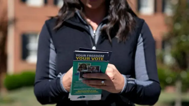 A woman hands out leaflets in the lead-up to the US midterms