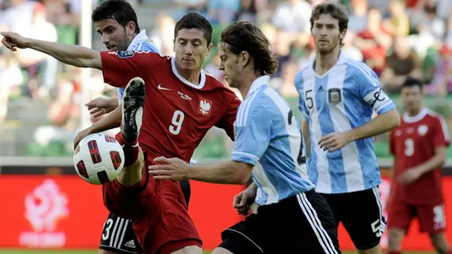 Robert Lewandowski (number nine) challenges for the ball with Christian Ansaldi (centre)