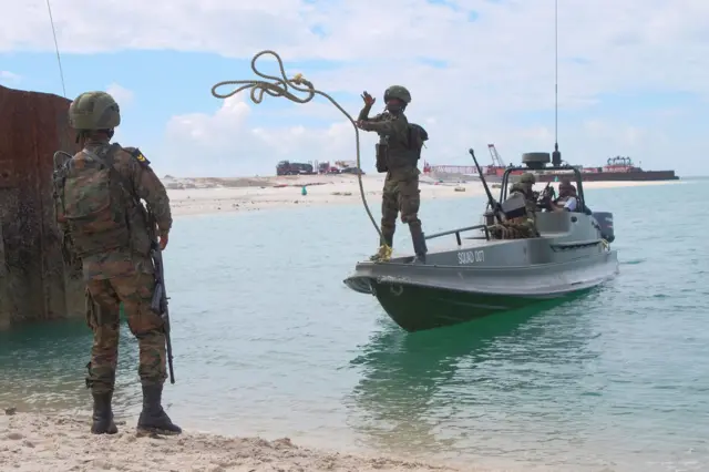 Rwandan soldiers prepare to dock a boat in the port city of Mocimboa da Praia, northern Mozambique, on August 13, 2021