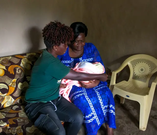 Gladys Wanga carrying a baby