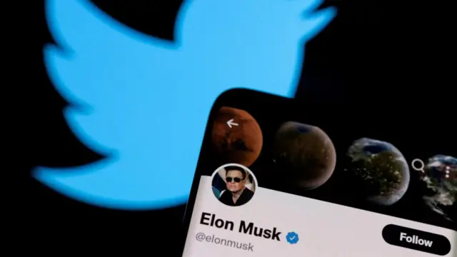 Elon Musk's Twitter account is seen on a smartphone in front of the Twitter logo in this photo illustration taken, April 15, 2022.