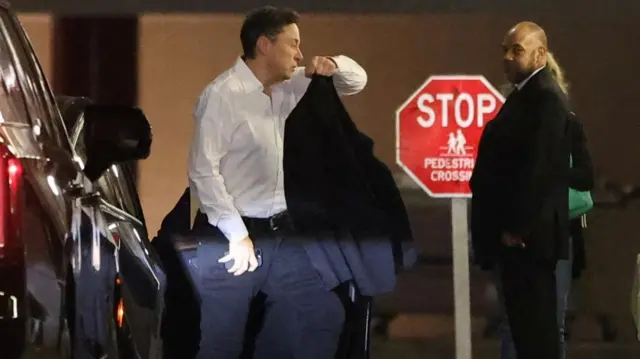 Elon Musk gets out of car, walking into an Investment Conference in Manhattan