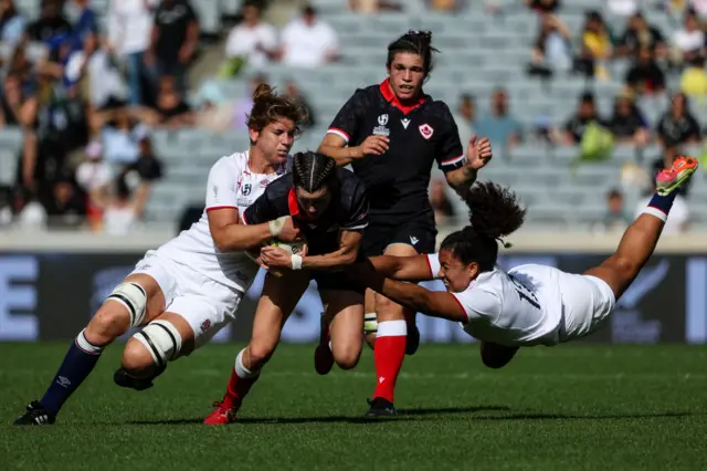 Canada's Elissa Alarie (C) is tackled by England's Tatyana Heard (R) and England's Sarah Hunter (L)