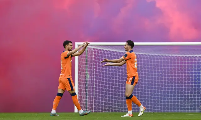 Barisic and Davies in front of a smoky red and blue background