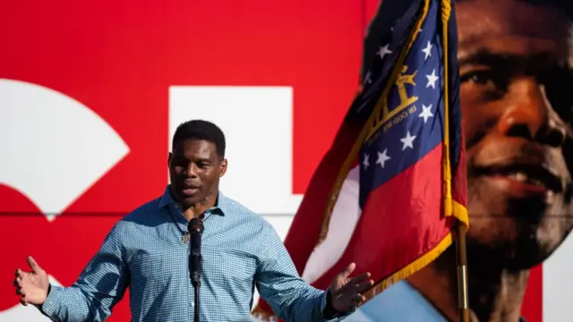 Walker speaking in front of a bus