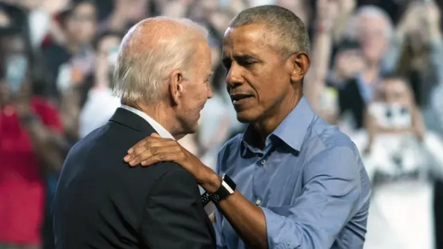 President Joe Biden speaks to former US President Barack Obama at a rally