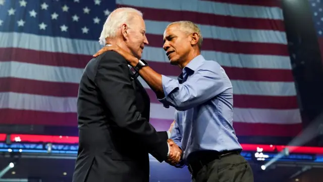 President Joe Biden and former President Barack Obama shake hands at a Democratic campaign event