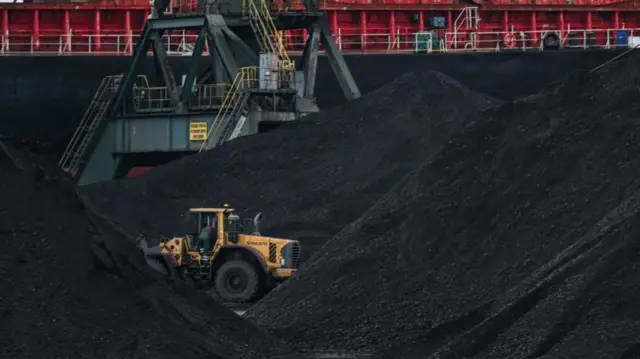 A vehicle sorts imported coal at Gdansk Port in Gdansk, Poland