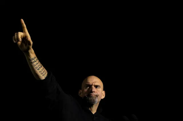 John Fetterman holding his hand up to supporters at a Pennsylvania campaign event