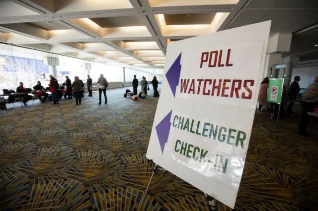 Poll watchers and challengers sign in before observing Michigan election workers pre-sort ballots