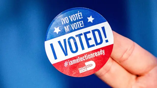 A person holds a Miami-Dade 'I voted' sticker during early voting in Florida