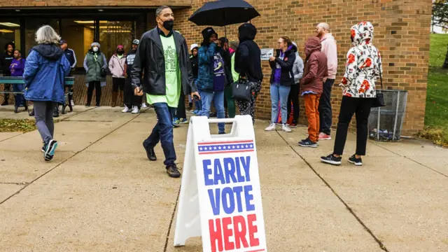 Voters line up to vote in Milwaukee, Wisconsin, in front of a sign that says: early vote here