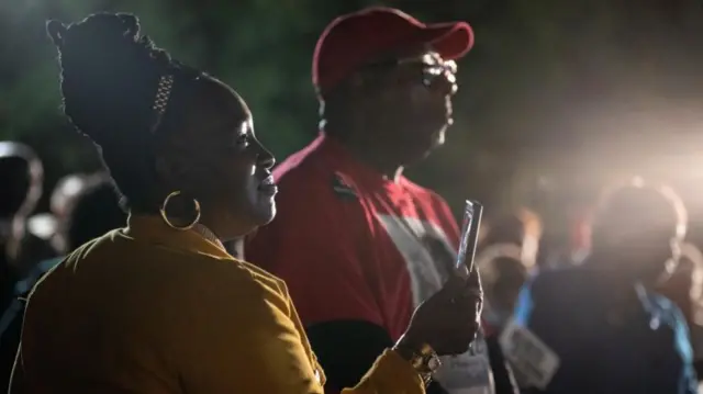 Supporters listen to a campaign speech from Reverend Raphael Warnock, Democratic Senator for Georgia