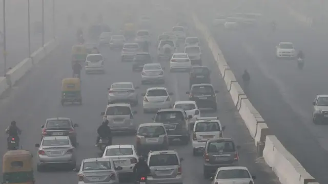 Morning traffic moves on the roads engulfed in smog, in New Delhi, India