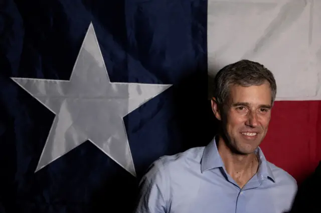 Beto O'Rourke in front of a Texas flag