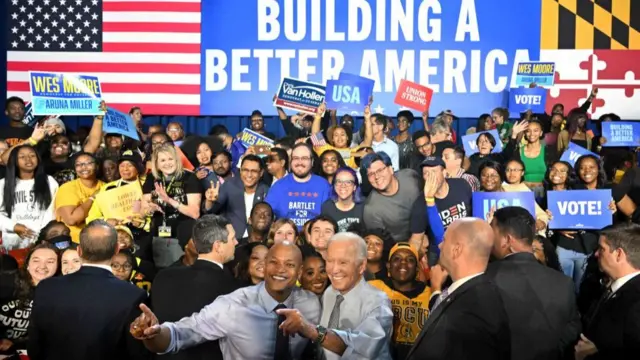 Wes Moore and US President Joe Biden pose for pictures with supporters during a rally on the eve of the US midterm elections, at Bowie State University in Bowie, Maryland, on 7 November 2022