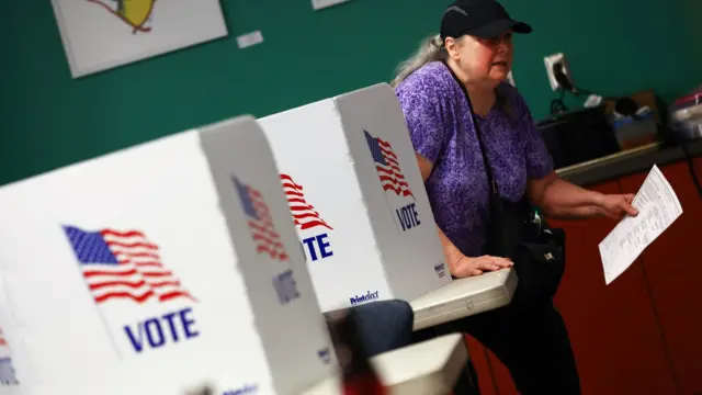 A voter carries her ballot at a polling station during the 2022 U.S. midterm election in downtown Harrisburg, Pennsylvania, U.S.,