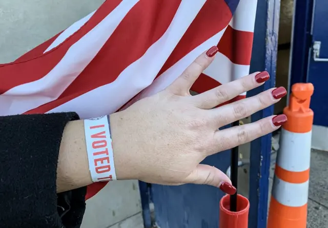 Hand with "I voted" bracelet