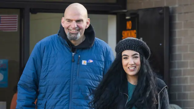 John Fetterman coming out of a polling booth with his partner