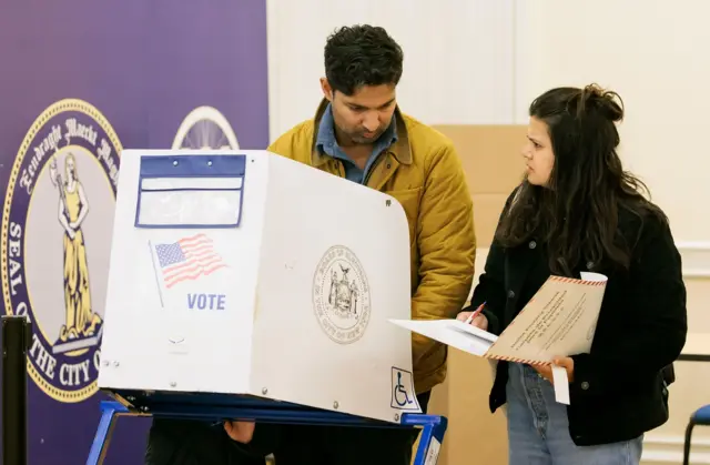 People in a voting booth at a polling site in Brooklyn Borough Hall