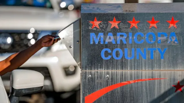 A voter in Maricopa County drops off a ballot