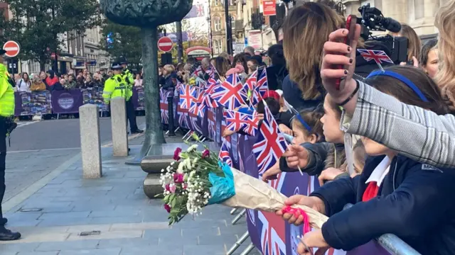 People with flowers to hand to the King