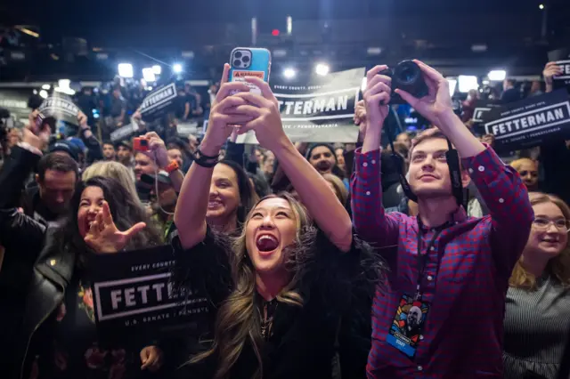 Cheering supporters in the crowd take pictures of Fetterman at his victory party