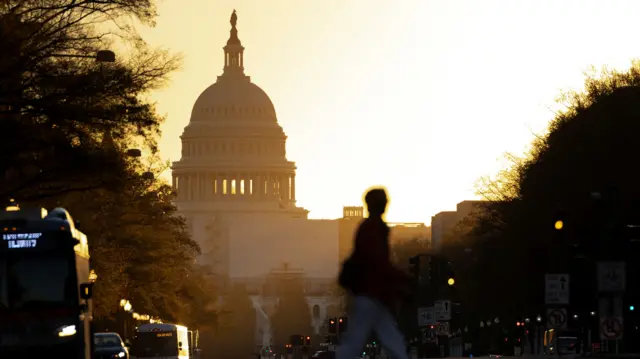 The sun shines behind the US Capitol